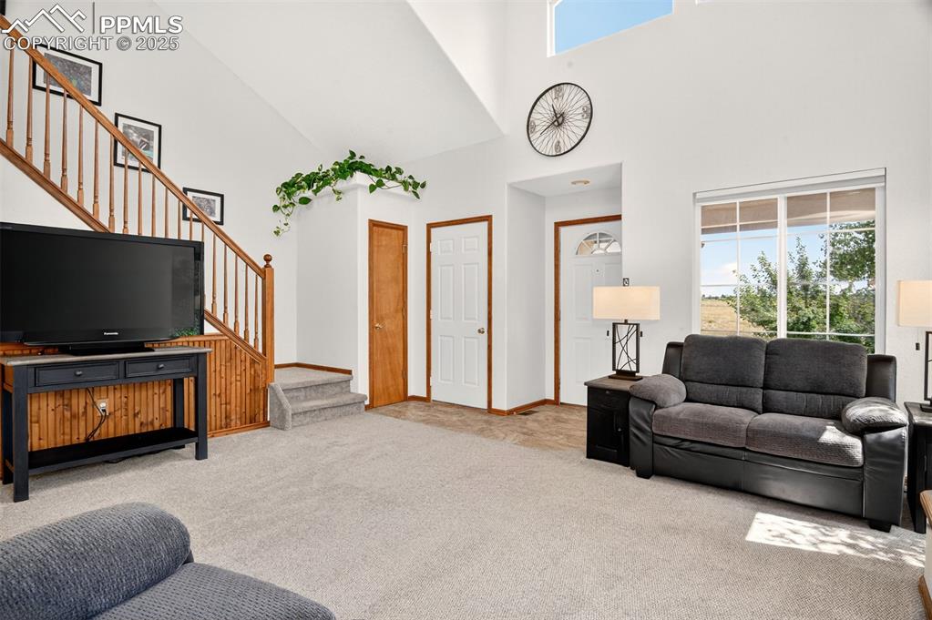 Image 6 of 40: Carpeted living room featuring healthy amount of natural light, a high ceil