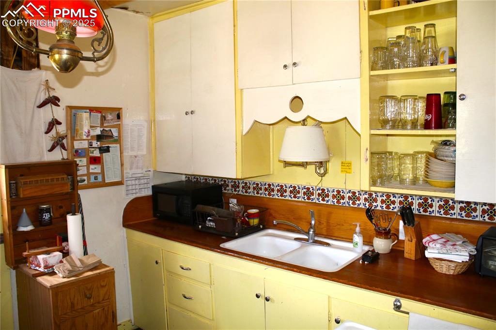 Image 21 of 28: Kitchen featuring black microwave and dark countertops