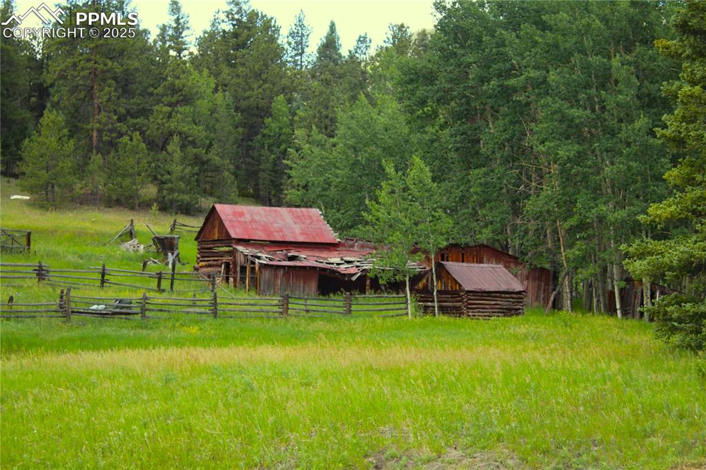Image 5 of 28: View of yard featuring a wooded view, an outbuilding, and a barn