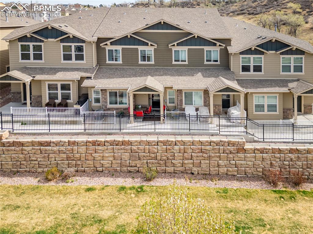 Image 1 of 26: View of front of property with a patio, roof with shingles, and stone sidin