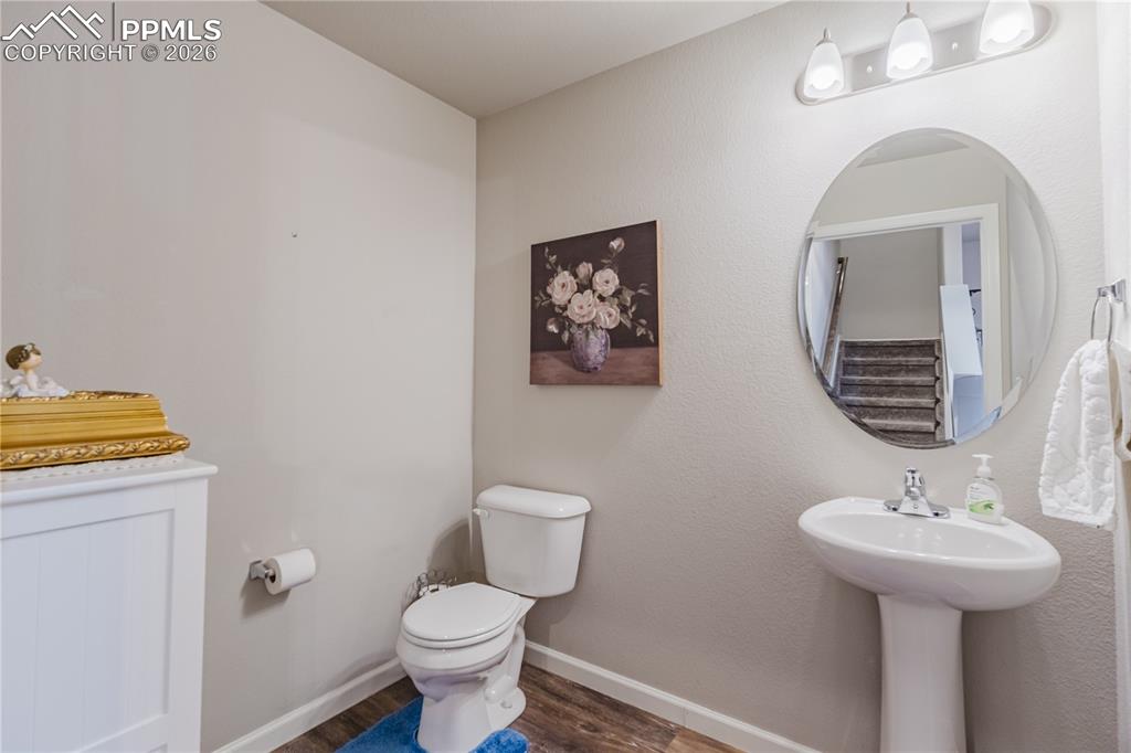 Image 10 of 26: Kitchen featuring dark wood finish cabinetry, open floor plan, light stone