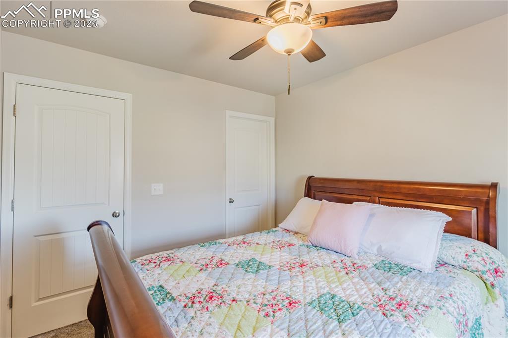 Image 14 of 26: Carpeted bedroom with ceiling fan and a closet