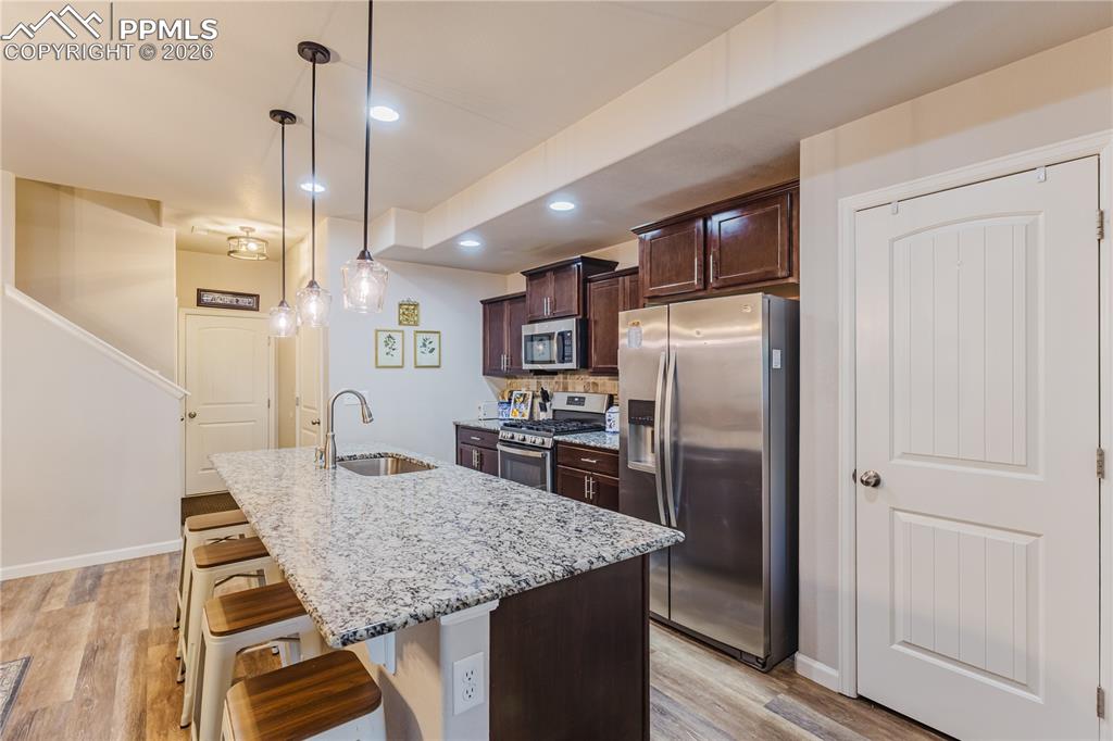 Image 6 of 26: Living room with a ceiling fan, light wood-type flooring, and hanging light