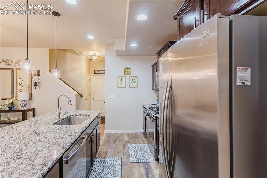 Image 7 of 26: Living room with a ceiling fan and dark wood-style flooring