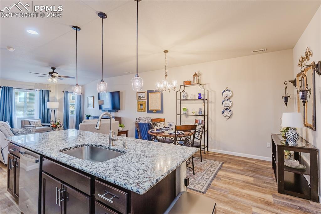 Image 8 of 26: Kitchen featuring a breakfast bar area, dark wood finish cabinetry, stainle