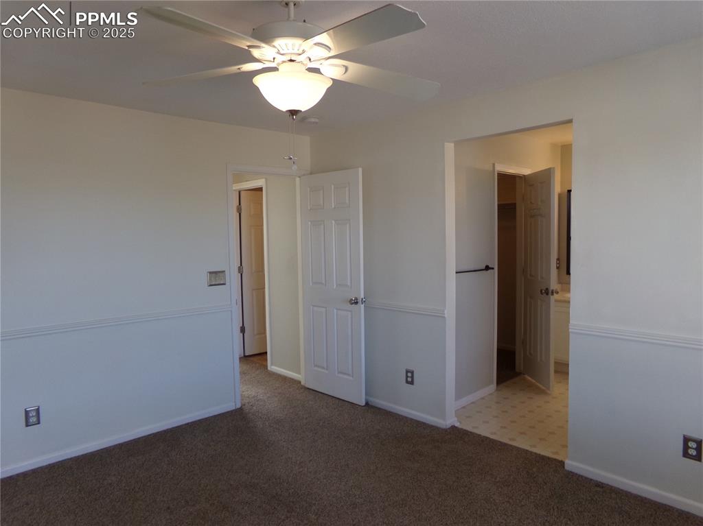 Image 17 of 29: Unfurnished bedroom with carpet flooring, a ceiling fan, and connected bath