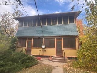 Image 4 of 50: Back of property with a sunroom