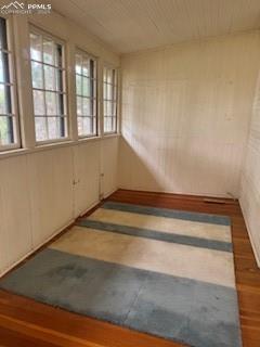 Image 41 of 50: Unfurnished room with wood finished floors and wood walls