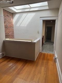 Image 42 of 50: Hall with a skylight and light wood-style flooring