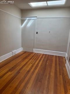 Image 43 of 50: Unfurnished room with light wood-type flooring and a skylight