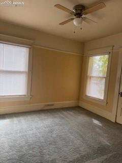 Image 44 of 50: Carpeted empty room with a ceiling fan and baseboards