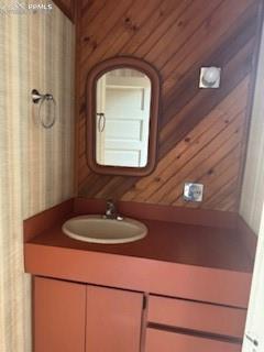 Image 46 of 50: Bathroom with vanity and wood walls
