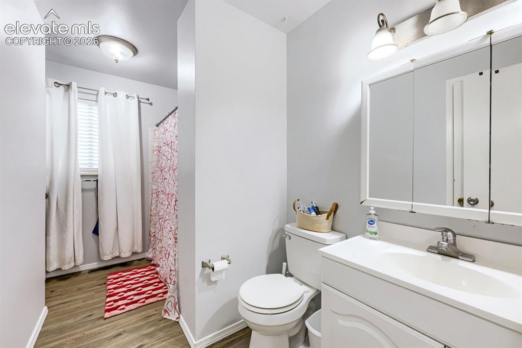 Image 12 of 26: White vanity with integrated sink, chrome faucet, and mirrored medicine cab