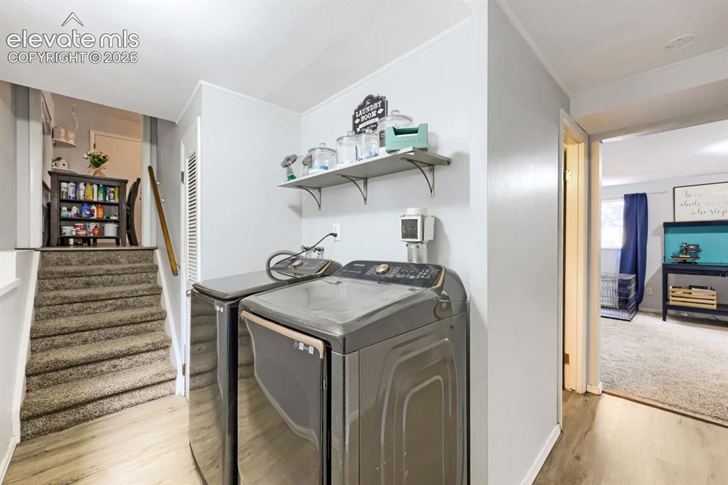 Image 17 of 26: Laundry area featuring wood-finish flooring, two large-capacity appliances,