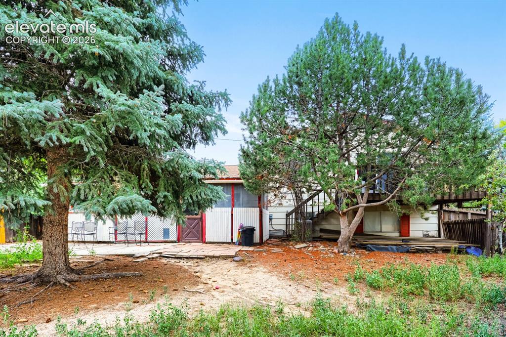 Image 24 of 26: Exterior featuring mature trees, a ground-level patio, and an upper-level d