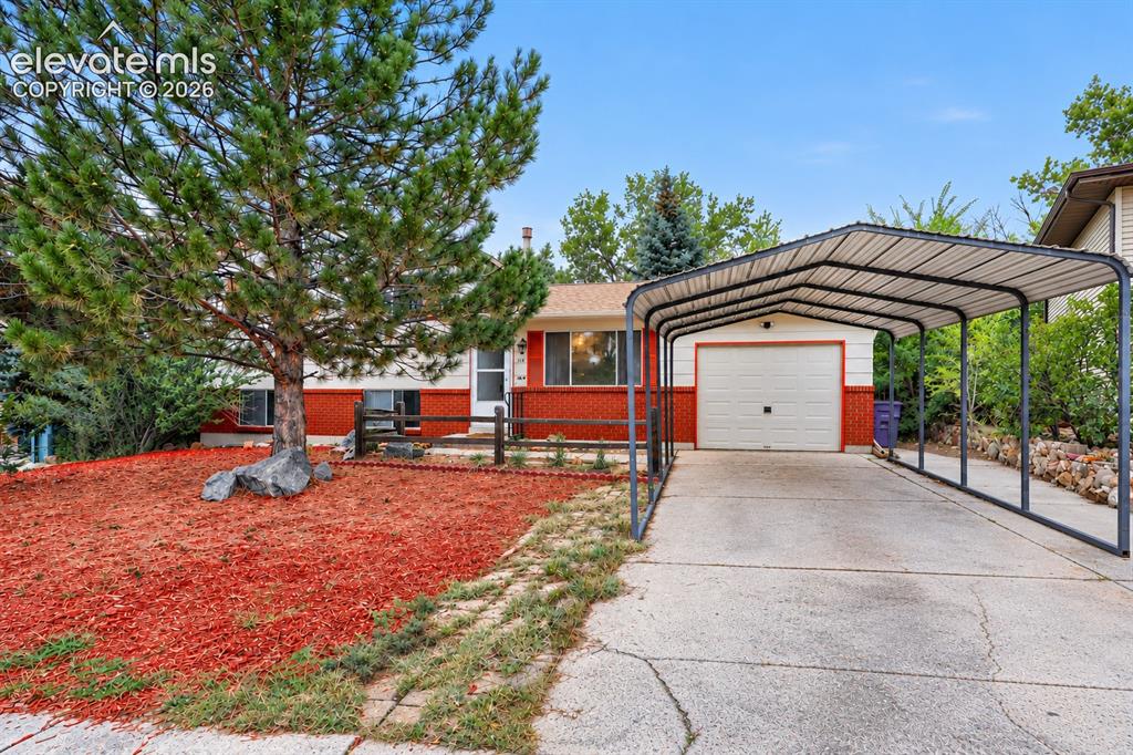 Image 26 of 26: Red brick lower exterior, light-colored upper exterior, attached garage, co