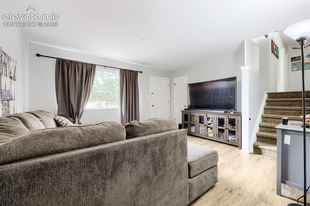 Image 4 of 26: Light wood-finish flooring, white painted walls, and a window with exterior