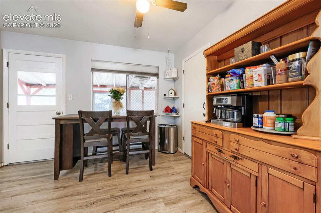 Image 5 of 26: Wood-finish flooring, built-in wooden hutch with open shelving, ceiling fan