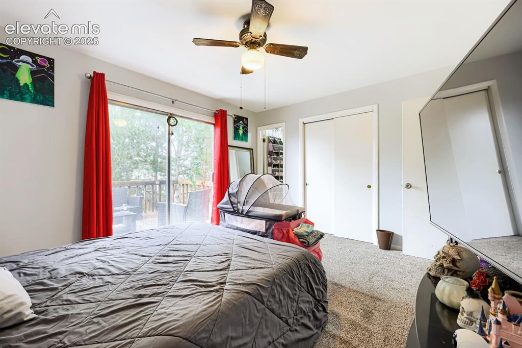 Image 9 of 26: Carpeted flooring with a ceiling fan light fixture, double closet doors, an