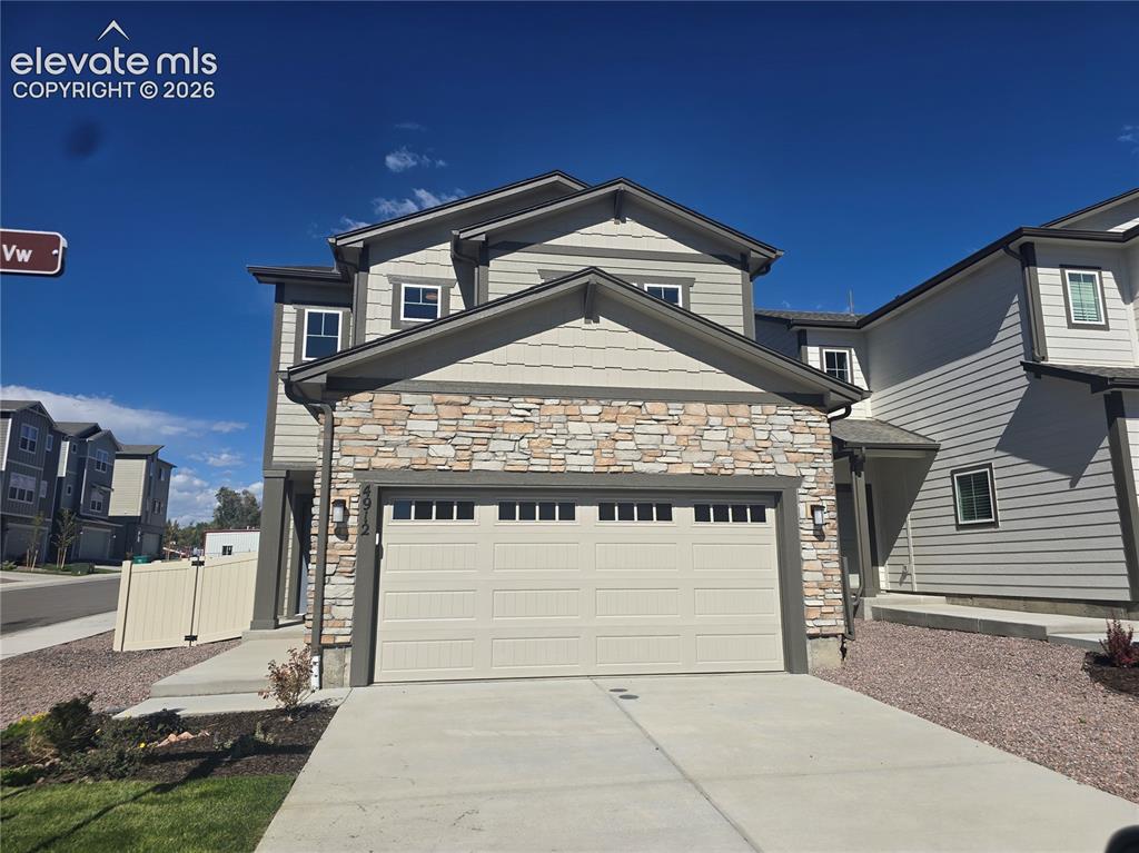 Image 1 of 26: Exterior featuring stone accents, horizontal siding, and a two-car garage w