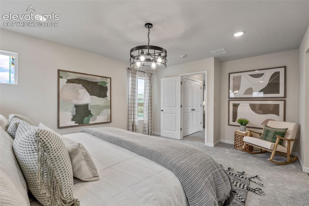 Image 18 of 26: Recessed lighting, a centered chandelier, wall-to-wall carpeting, and white