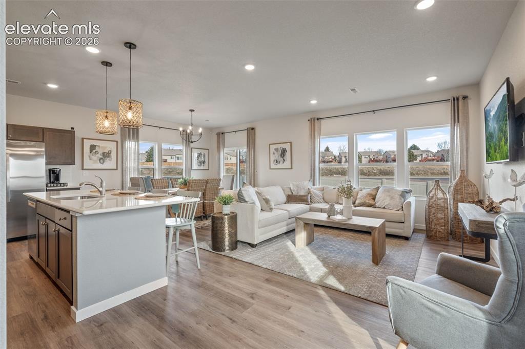 Image 2 of 26: Open-concept living area featuring wood-finish flooring, a kitchen island w