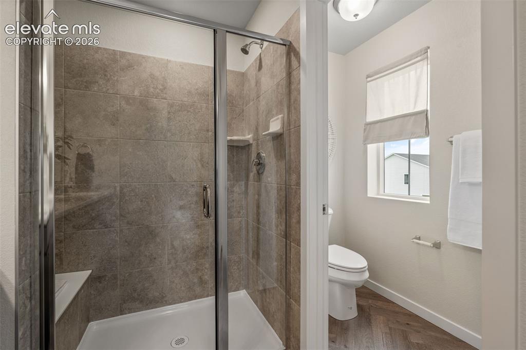 Image 20 of 26: Walk-in shower with clear glass enclosure and built-in bench
