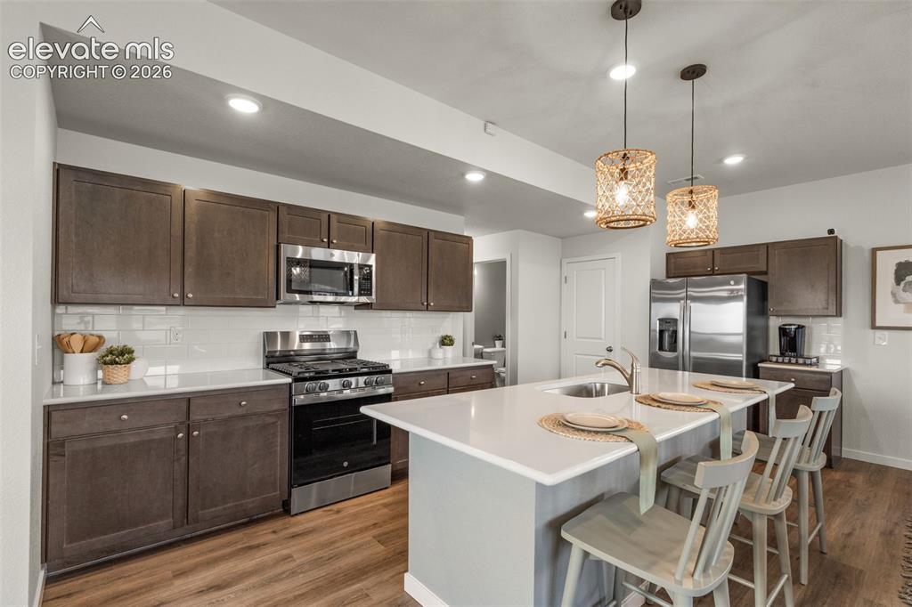 Image 6 of 26: Kitchen featuring a center island, stainless steel appliances, wood-finish 