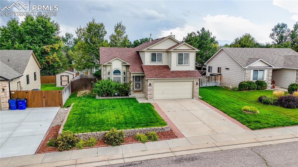 Caption: View of front of house with driveway, roof with shingles, an attached garage, brick siding, and a ch
