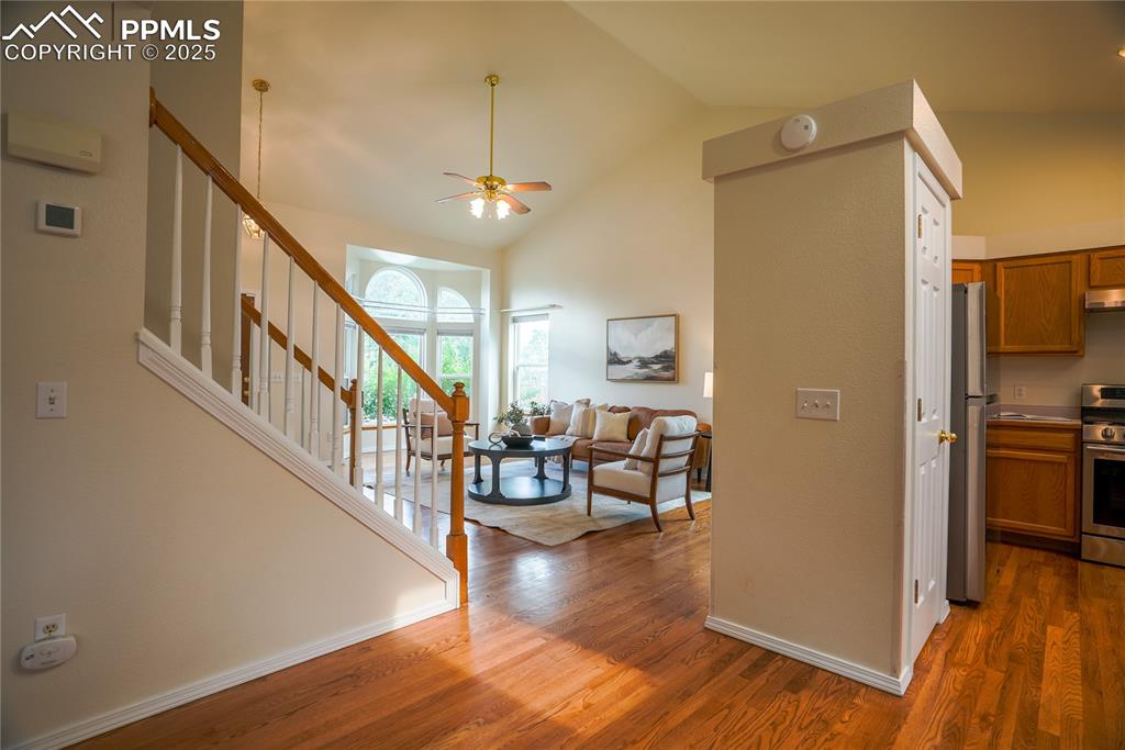 Image 17 of 37: Entrance foyer with stairway, wood finished floors, ceiling fan, and high v