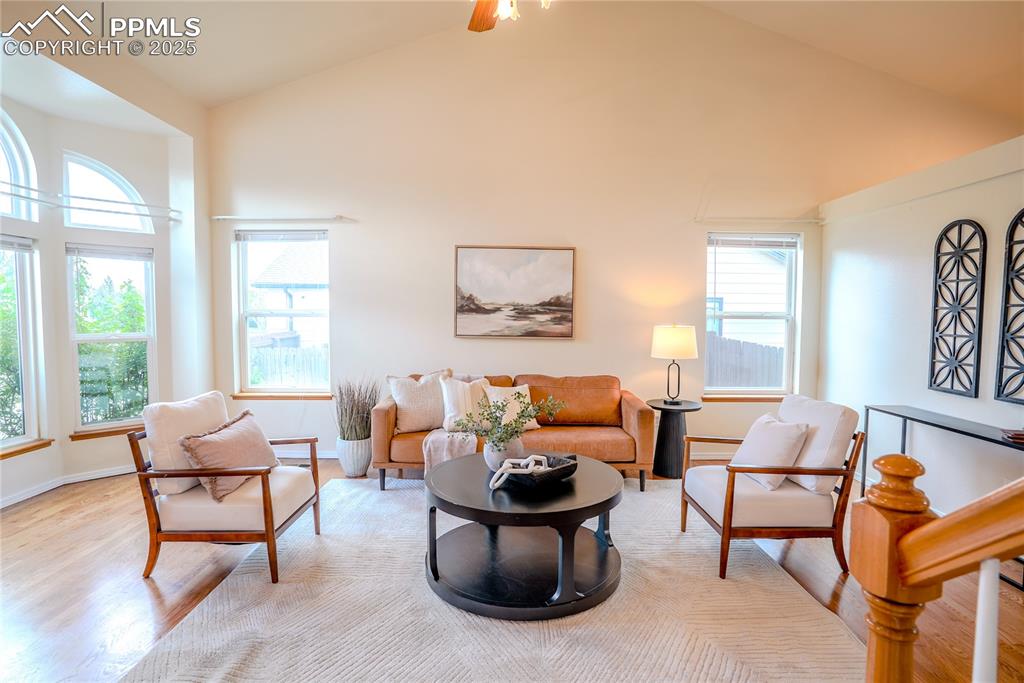 Image 2 of 37: Living room featuring wood finished floors, ceiling fan, and high vaulted c