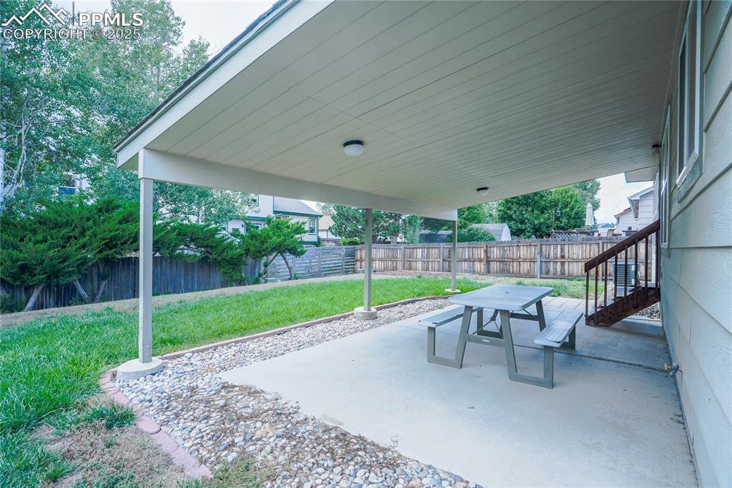 Image 33 of 37: Fenced backyard featuring a patio area and outdoor dining space