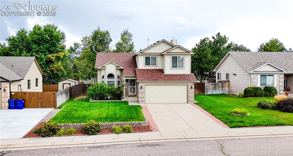 Image 37 of 37: Traditional home with driveway, a chimney, brick siding, a garage, and roof