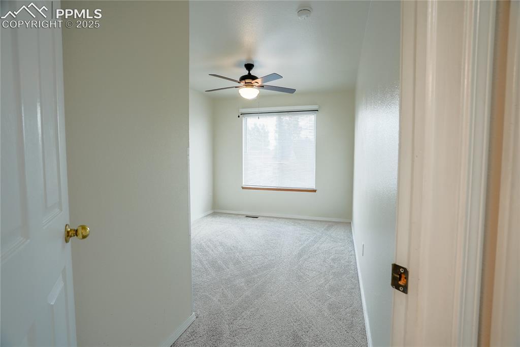 Image 7 of 37: Carpeted spare room with baseboards and ceiling fan