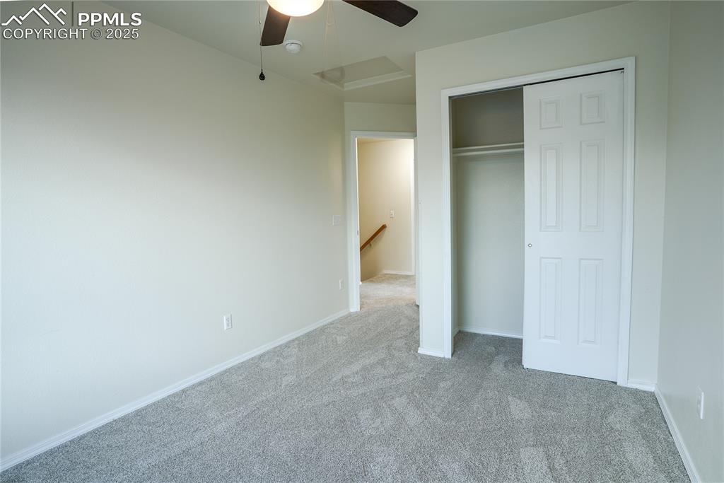 Image 8 of 37: Unfurnished bedroom featuring carpet, a closet, a ceiling fan, and attic ac