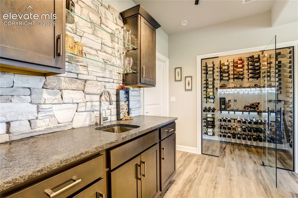 Image 32 of 50:  Leathered granite countertops, stone backsplash, beverage storage, and exc