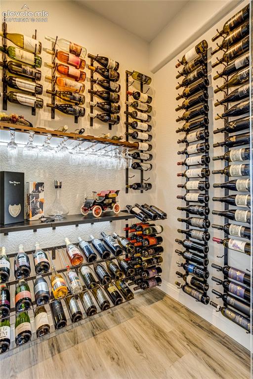 Image 33 of 50: A striking glass-enclosed wine cellar creates a distinctive focal point wit