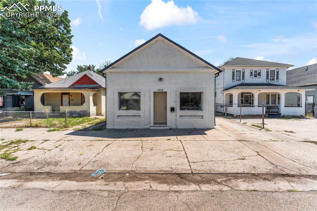 Caption: View of front of home featuring a porch and stucco siding