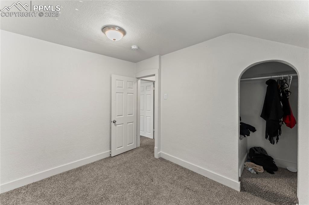 Image 17 of 19: Unfurnished bedroom with carpet, a textured ceiling, and a closet