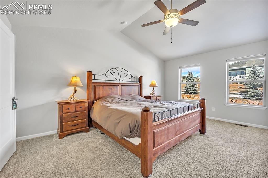 Image 12 of 45: Bedroom with light carpet and vaulted ceiling