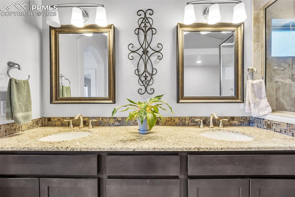 Image 17 of 45: Bathroom featuring a sink, backsplash, and double vanity
