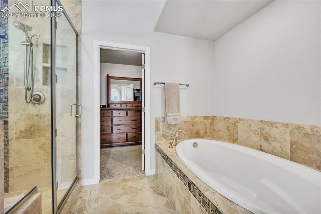 Image 18 of 45: Full bathroom featuring a stall shower and an oversized bath