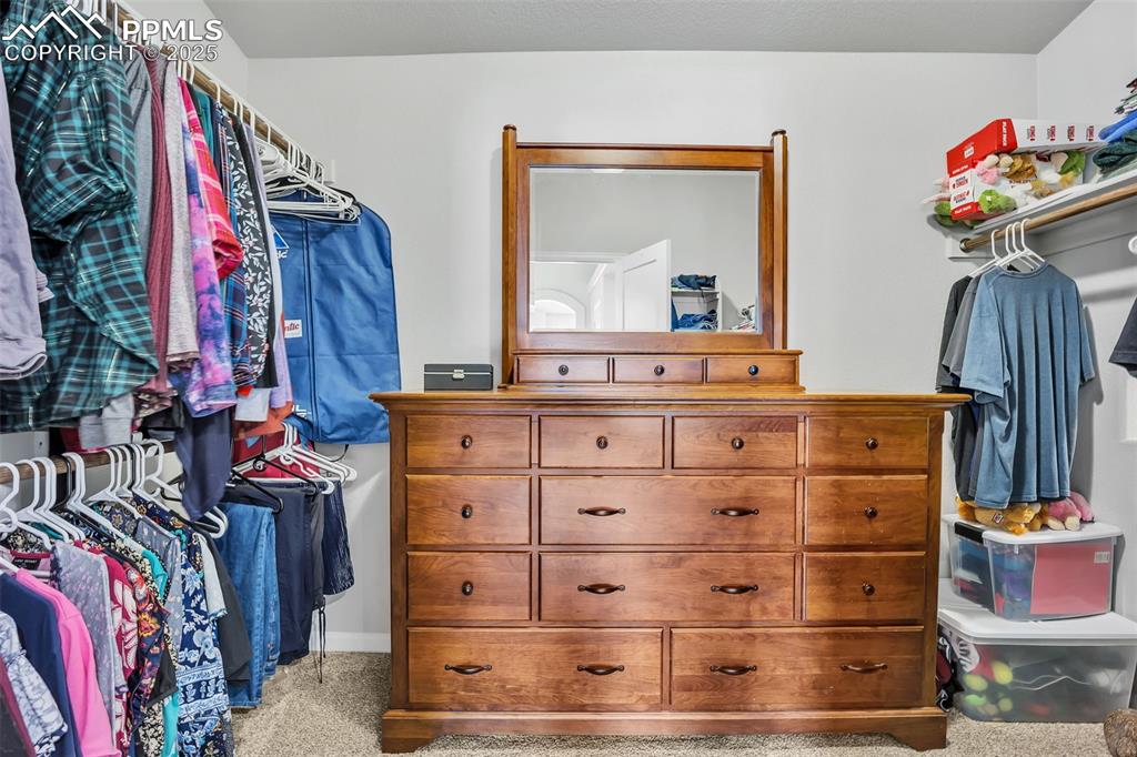 Image 19 of 45: Walk in closet with light carpet