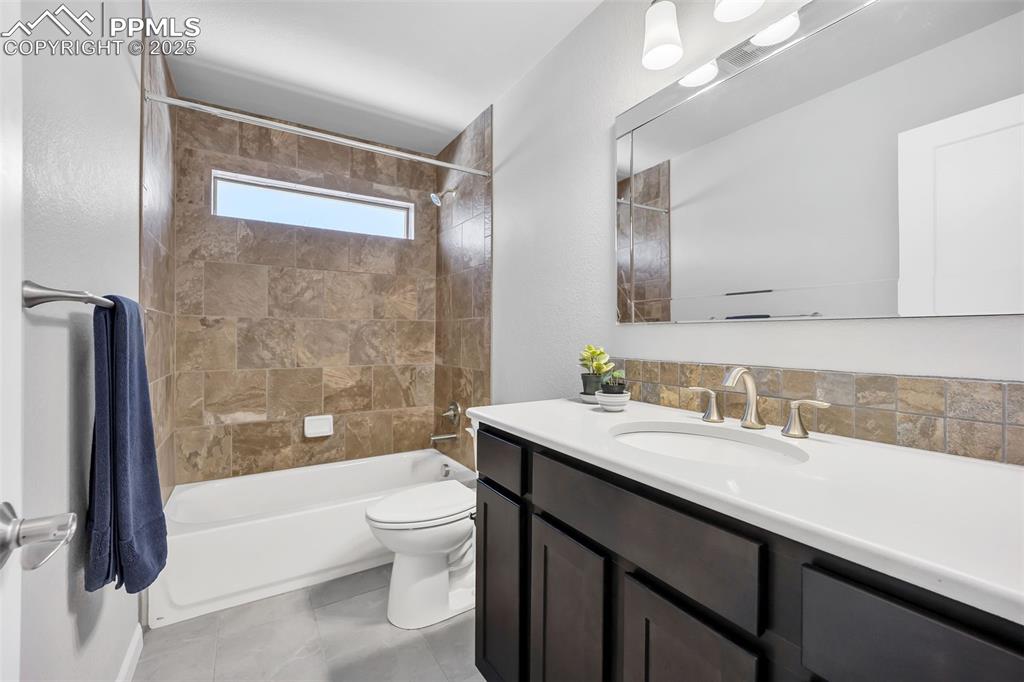 Image 25 of 45: Bathroom featuring tub / shower combination, vanity, and toilet