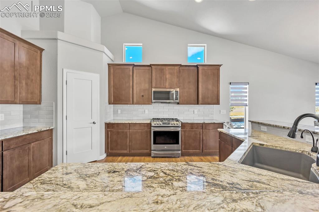 Image 5 of 45: Kitchen with tasteful backsplash, appliances with stainless steel finishes,
