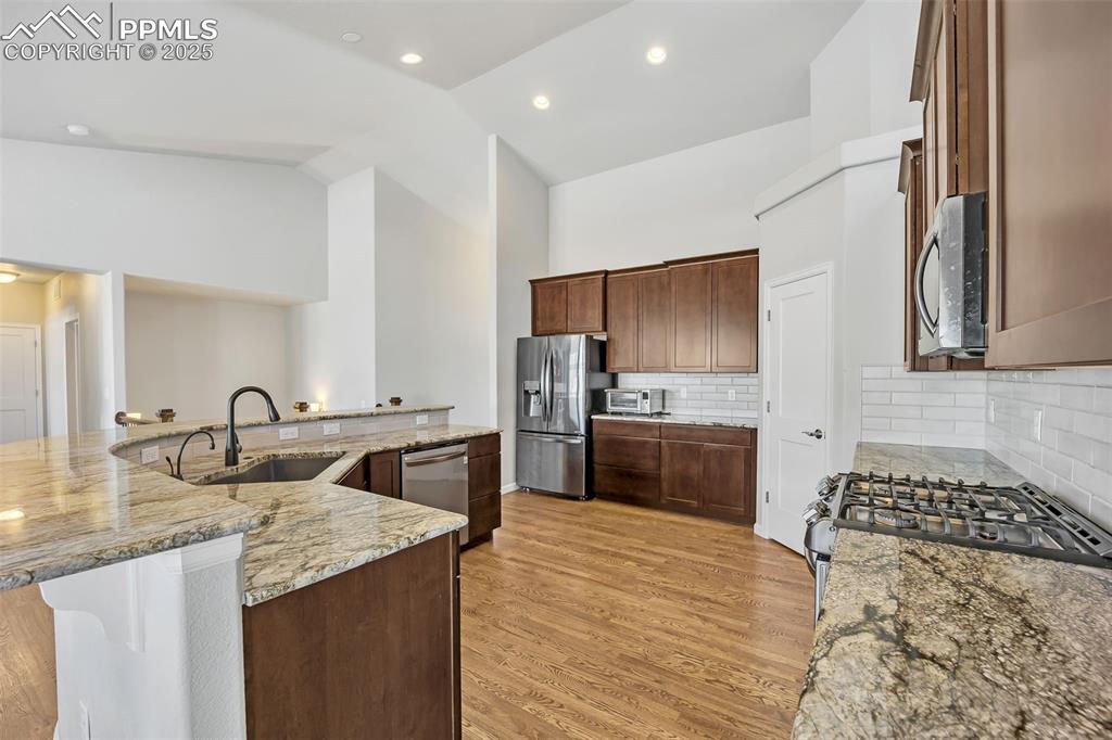 Image 7 of 45: Kitchen featuring light wood-style flooring, appliances with stainless stee