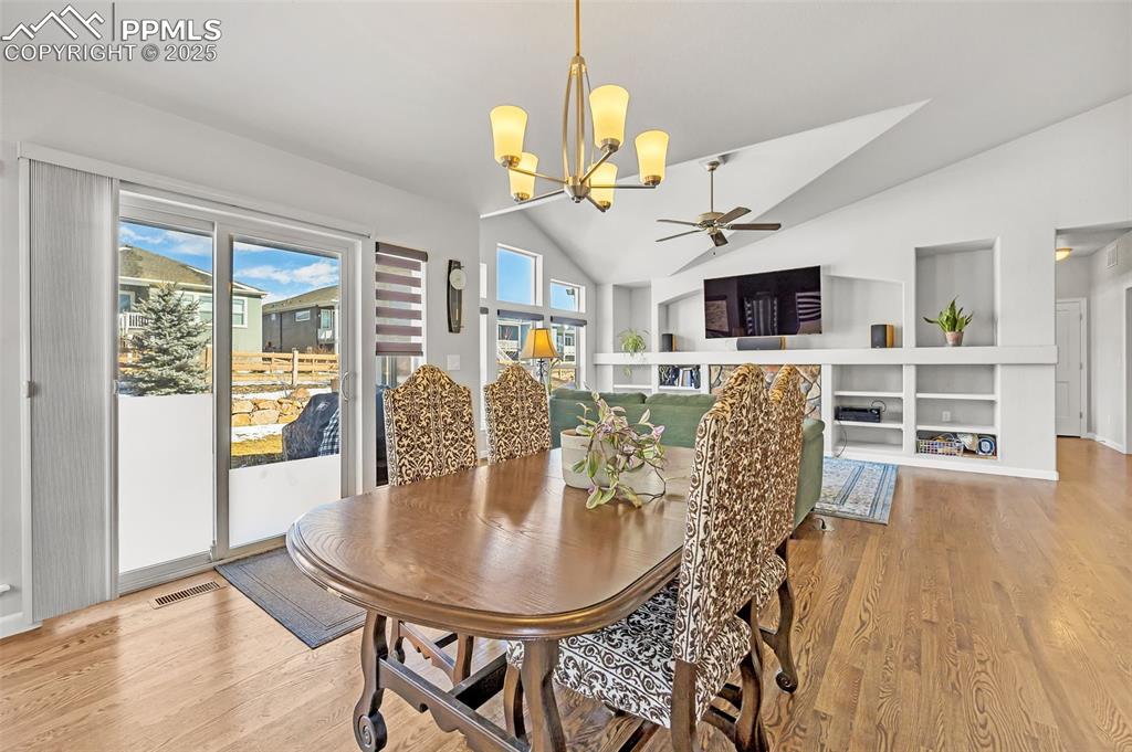 Image 9 of 45: Dining room featuring lofted ceiling, light wood-style flooring opening int