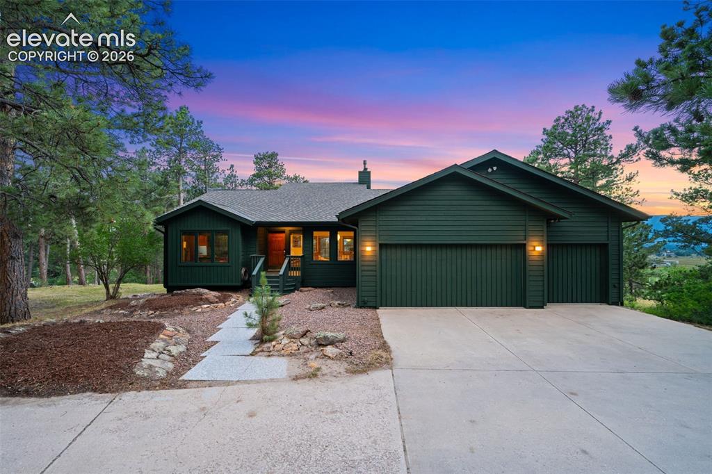 Image 1 of 47: Single-story residence featuring deep green siding, an attached two-car gar