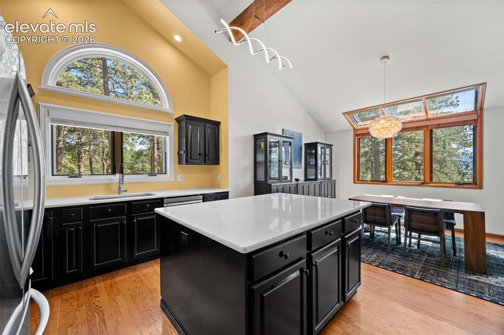 Image 14 of 47: Open-concept kitchen and dining area featuring vaulted ceilings with expose