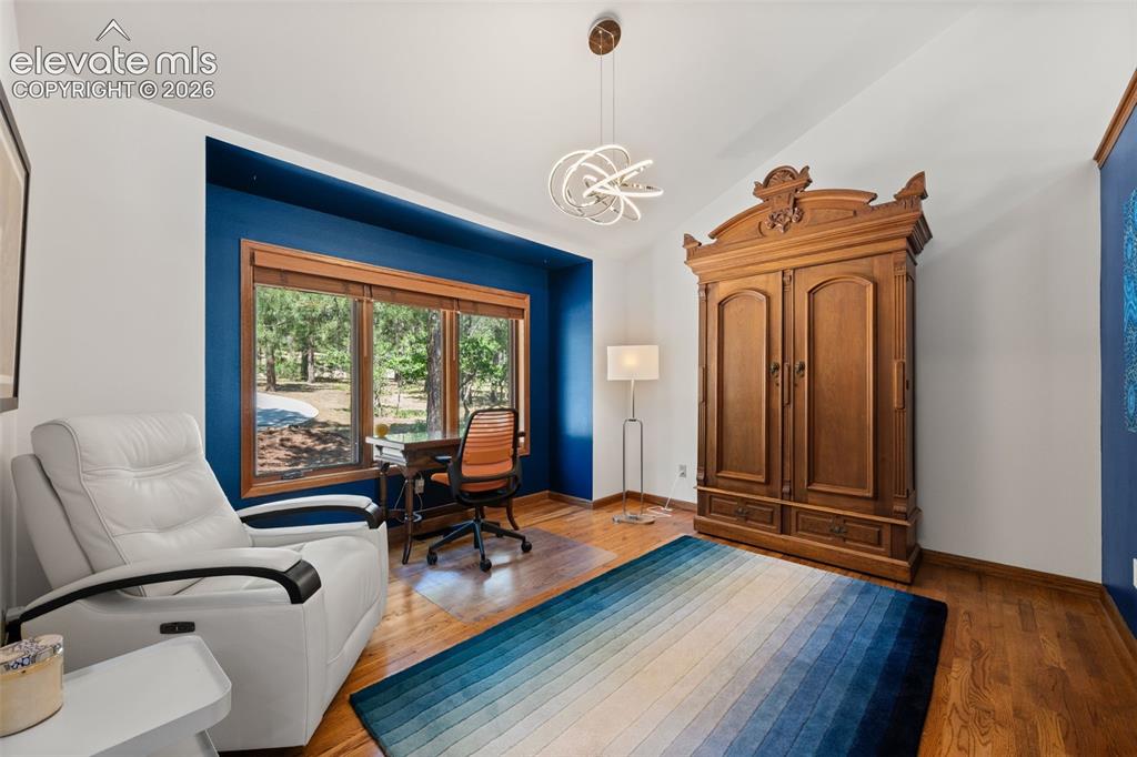 Image 17 of 47: Spacious room featuring wood-finish flooring, a large window with wood trim